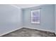 Simple yet cozy bedroom with neutral walls, gray floors, and a bright window at 8742 Belt Ln, Fort Mill, SC 29707