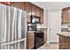 Modern kitchen featuring stainless steel refrigerator, black appliances, and wooden cabinets at 8742 Belt Ln, Fort Mill, SC 29707