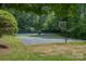 Community basketball court surrounded by tall trees providing shade and privacy at 9022 Taunton Dr, Huntersville, NC 28078