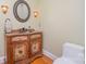 Charming powder room with a decorative vanity, round mirror, sconce lighting, and hardwood floors at 9022 Taunton Dr, Huntersville, NC 28078