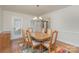 Light-filled dining area with hardwood floors, a classic chandelier, and natural light flooding the room at 9022 Taunton Dr, Huntersville, NC 28078