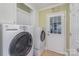 Bright laundry room features a modern washer and dryer, ample storage, and exterior door at 9022 Taunton Dr, Huntersville, NC 28078