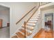 Elegant staircase with hardwood steps and white risers leads to the upper level at 9022 Taunton Dr, Huntersville, NC 28078