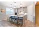 Stylish kitchen featuring a large island with seating, modern pendant lights, and stainless steel appliances at 9851 Quercus Ln, Huntersville, NC 28078