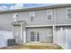 Backyard view features a patio, white fence, and sliding glass door entry into this home at 10422 Stokeshill Ct, Pineville, NC 28134