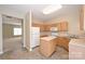 Kitchen featuring light wood cabinets, white appliances, and an island with neutral countertops at 10422 Stokeshill Ct, Pineville, NC 28134
