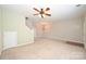 Spacious living room featuring neutral walls, ceiling fan and lighting, and access to other rooms at 10422 Stokeshill Ct, Pineville, NC 28134