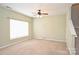 A well-lit living room with carpeted floors, neutral walls, and a view of the staircase at 10422 Stokeshill Ct, Pineville, NC 28134