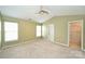 Main bedroom featuring neutral carpet, windows, ceiling fan and ensuite access at 10422 Stokeshill Ct, Pineville, NC 28134
