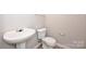 Standard powder room with a pedestal sink, toilet and neutral wall paint at 10422 Stokeshill Ct, Pineville, NC 28134