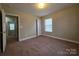 This bedroom includes carpeting and a window for natural light at 10927 Kinnairds St, Charlotte, NC 28278