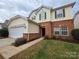 Charming two-story home with a two-car garage, brick accents, and a well-maintained front lawn at 10927 Kinnairds St, Charlotte, NC 28278