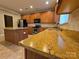 Close-up of kitchen featuring granite counters, stainless steel sink, tile backsplash and wood cabinets at 10927 Kinnairds St, Charlotte, NC 28278