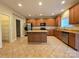 Open kitchen featuring stainless steel appliances, wood cabinets, tile floor and a kitchen island at 10927 Kinnairds St, Charlotte, NC 28278