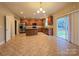 Open kitchen featuring stainless steel appliances, wood cabinets, tile floor and a breakfast area with sliding glass door at 10927 Kinnairds St, Charlotte, NC 28278