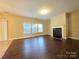 Spacious living room featuring hardwood floors, a fireplace, and large windows at 10927 Kinnairds St, Charlotte, NC 28278
