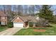 Aerial view of a well-maintained brick home with a two-car garage and beautifully landscaped front yard at 11542 Laurel View Dr, Charlotte, NC 28273