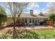 Lovely backyard featuring a stone patio with dining area, lush greenery, and a grill at 11542 Laurel View Dr, Charlotte, NC 28273