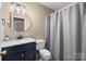 Bathroom featuring granite countertop sink with updated fixtures, toilet, and a shower with curtain at 11542 Laurel View Dr, Charlotte, NC 28273