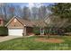 Charming brick home featuring an attached two-car garage, well-manicured lawn, and mature landscaping at 11542 Laurel View Dr, Charlotte, NC 28273