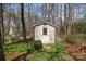 Backyard shed with a small door and a cozy space, surrounded by lush trees at 11542 Laurel View Dr, Charlotte, NC 28273