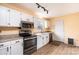 White cabinets and stainless steel appliances adorn this sunny kitchen with wood-look flooring at 1228 Hidden Creek Cir, Hickory, NC 28602