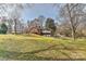 A grassy backyard featuring a brick home with a deck and sunroom at 1235 Robinhood Cir, Charlotte, NC 28227