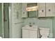 Bathroom featuring green tiles, vintage fixtures, and ample storage space for a classic design at 1235 Robinhood Cir, Charlotte, NC 28227