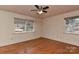 Comfortable bedroom with hardwood floors, neutral walls, and natural light from two windows at 1235 Robinhood Cir, Charlotte, NC 28227