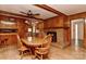 Classic dining room with a wooden table, brick fireplace, and elegant wood paneling at 1235 Robinhood Cir, Charlotte, NC 28227