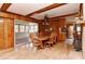 Warm dining room with wood paneled walls, brick fireplace, and sliding door to sunroom at 1235 Robinhood Cir, Charlotte, NC 28227