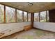 Enclosed sunroom with multiple windows offering natural light and views of the surrounding greenery at 1235 Robinhood Cir, Charlotte, NC 28227