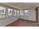 Sunroom featuring multiple windows, wood paneled walls, and access to the outdoors with a red mosaic tile floor at 1235 Robinhood Cir, Charlotte, NC 28227