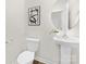 Half bath featuring pedestal sink, round mirror, and modern decor at 124 Rustling Waters Dr, Mooresville, NC 28117