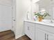 Bathroom with double sink vanity, framed mirror, and wood-look flooring at 124 Rustling Waters Dr, Mooresville, NC 28117