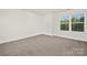 Bright, open bedroom featuring plush carpeting and a large window with natural light at 124 Rustling Waters Dr, Mooresville, NC 28117