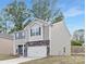 Charming two-story home featuring stone accents, gray siding, a two-car garage, and a well-maintained lawn at 124 Rustling Waters Dr, Mooresville, NC 28117