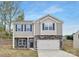 Charming two-story home featuring stone accents, gray siding, a two-car garage, and a well-maintained lawn at 124 Rustling Waters Dr, Mooresville, NC 28117