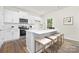Bright kitchen featuring white cabinets, stainless steel appliances, and a quartz-topped island with seating at 124 Rustling Waters Dr, Mooresville, NC 28117