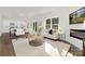 Bright, open-concept living room featuring large windows, modern decor, and stylish furnishings with new hardwood style floors at 124 Rustling Waters Dr, Mooresville, NC 28117