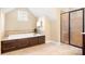 Elegant bathroom featuring a soaking tub with dark wood finish and glass-enclosed shower at 13122 Long Common Pkwy, Huntersville, NC 28078