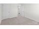 A neutral bedroom features a door to the hallway and an ensuite bathroom at 136 S Bell Ave, Albemarle, NC 28001