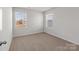 A bright bedroom features two windows and neutral carpet at 136 S Bell Ave, Albemarle, NC 28001