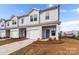 Attractive townhome showcasing a one-car garage, neutral siding, and meticulously maintained landscaping at 136 S Bell Ave, Albemarle, NC 28001