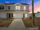 Charming townhome featuring a one car garage, neutral siding, and well manicured landscaping at 136 S Bell Ave, Albemarle, NC 28001