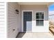 View of the front door with the house numbers, an outdoor light, and a window at 136 S Bell Ave, Albemarle, NC 28001
