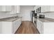 Contemporary kitchen boasts stainless steel appliances, granite countertops, white cabinets, and wood-look floors at 136 S Bell Ave, Albemarle, NC 28001