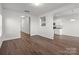 Open-concept living area with wood-look floors, neutral walls, and an attached kitchen space at 136 S Bell Ave, Albemarle, NC 28001