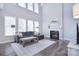 Bright living room with tall ceilings, hardwood floors, a gray couch, and a fireplace at 1516 Bucklebury Ct, Charlotte, NC 28269