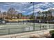 Outdoor tennis courts with black fencing, shaded benches, and well-maintained playing surfaces at 19622 River Falls Dr, Davidson, NC 28036